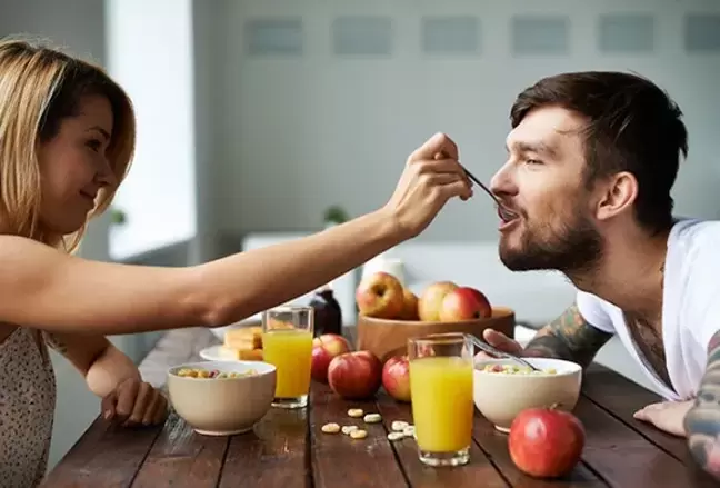 a woman feeds a man nuts to increase his potency